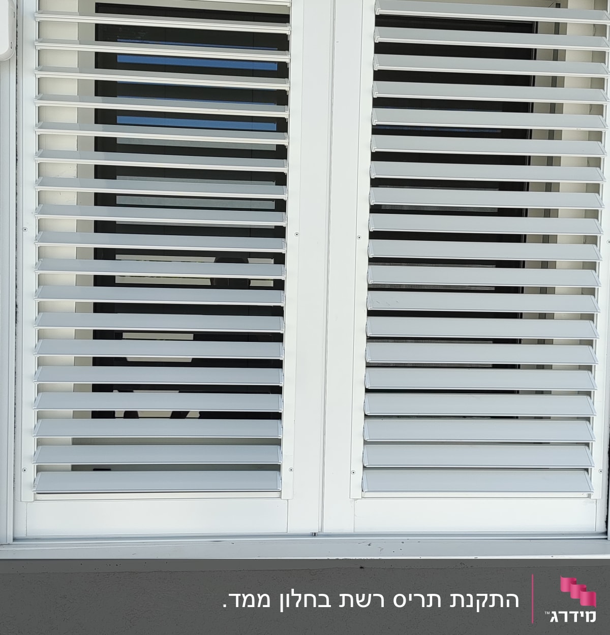 תריסי אלומיניום לבנים על חלון זכוכית